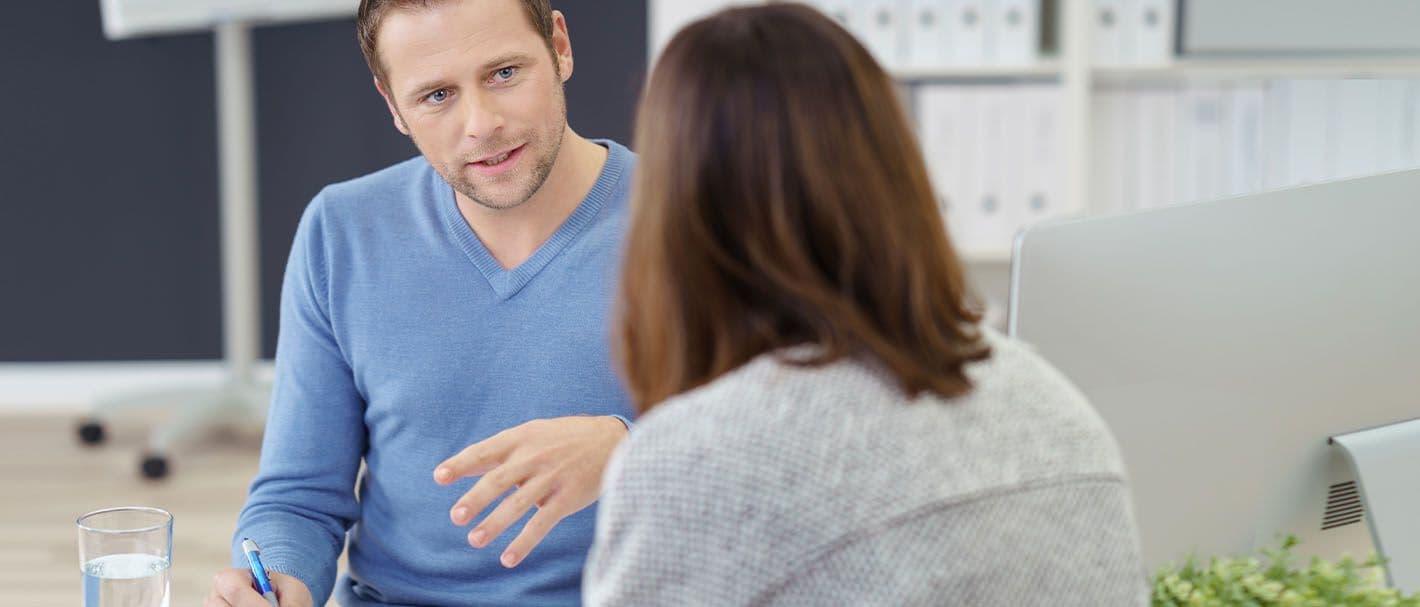Mann führt ein Beratungsgespräch mit einer Frau.
